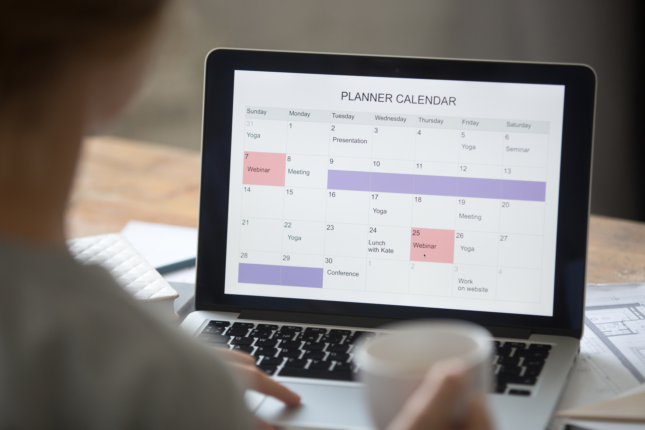 Open laptop on the desk, planner calendar on the screen